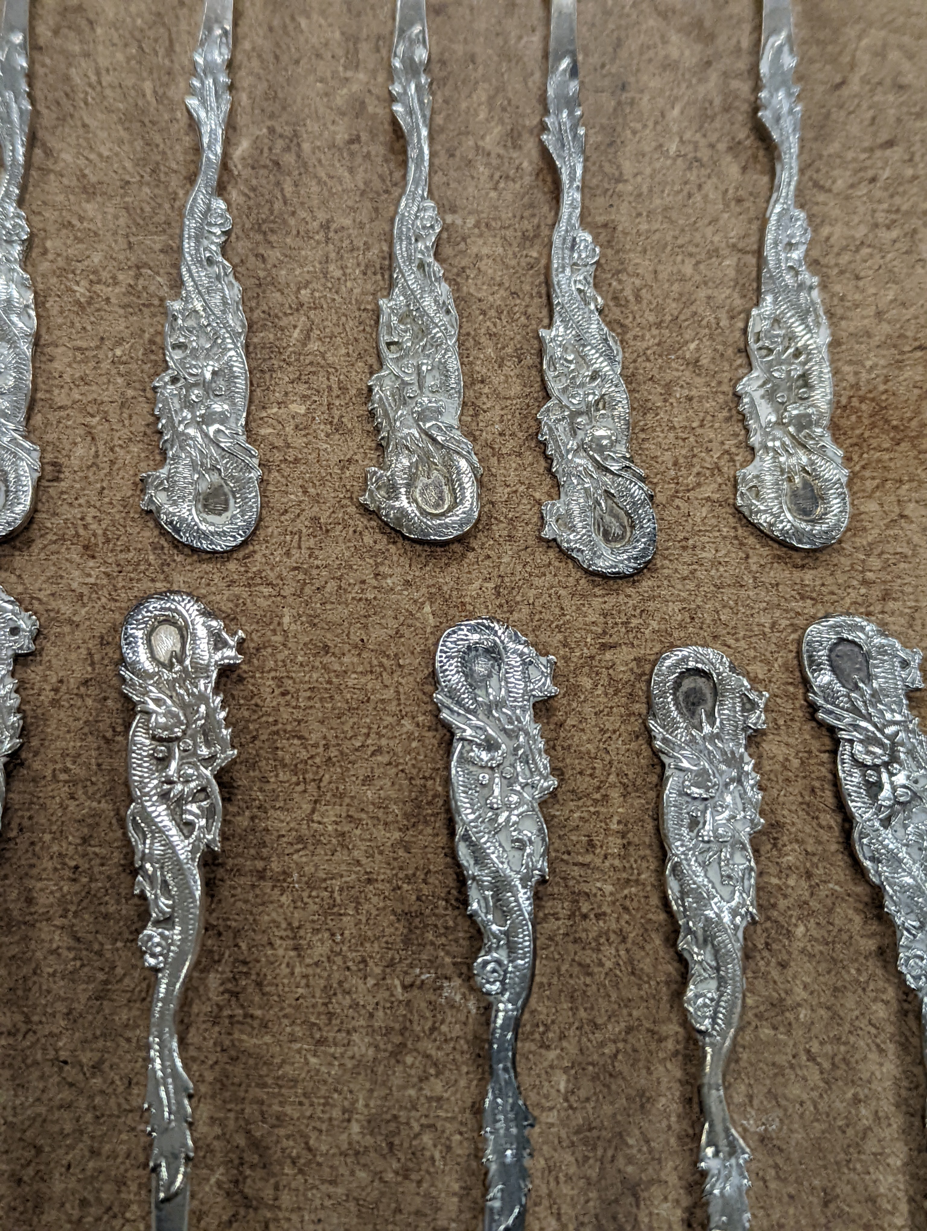 A set of twelve Chinese sterling tea forks, with dragon handles by YCCo and eleven similar teaspoons, 8oz.